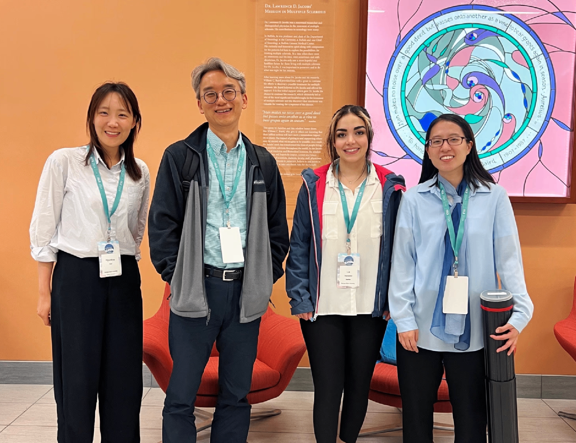 Research team at conference with orange background and artistic display