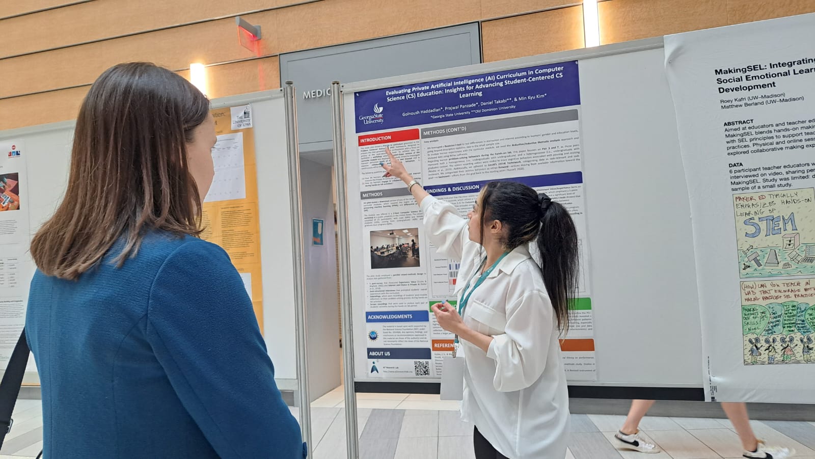 Researcher explaining Private AI curriculum poster at academic conference